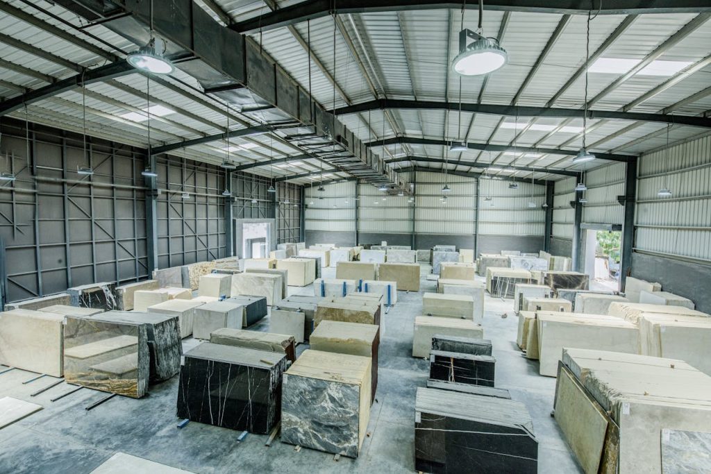 interior-of-warehouse-5827062 Expansive warehouse filled with large stone slabs for industrial use.